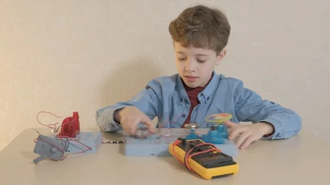 The boy studying electronics. Uses a digital multimeter and led strip Stock Footage 130108249