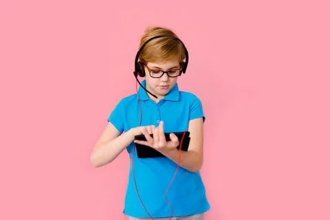 Boy studying homework with tablet pc and earphones during his online lesson.. Stock Photos