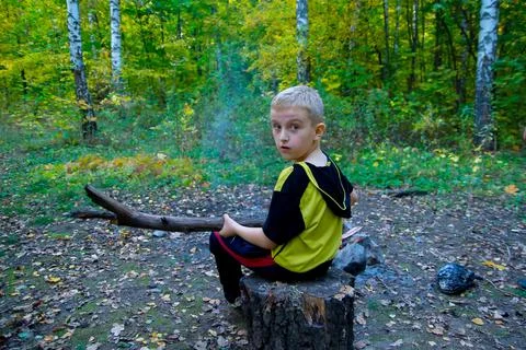 A boy on a stump with a log. Foto stock