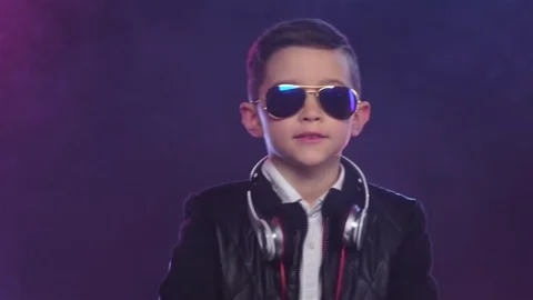 Boy in stylish glasses dances on colored smoky, slow motion Vidéo 75916667