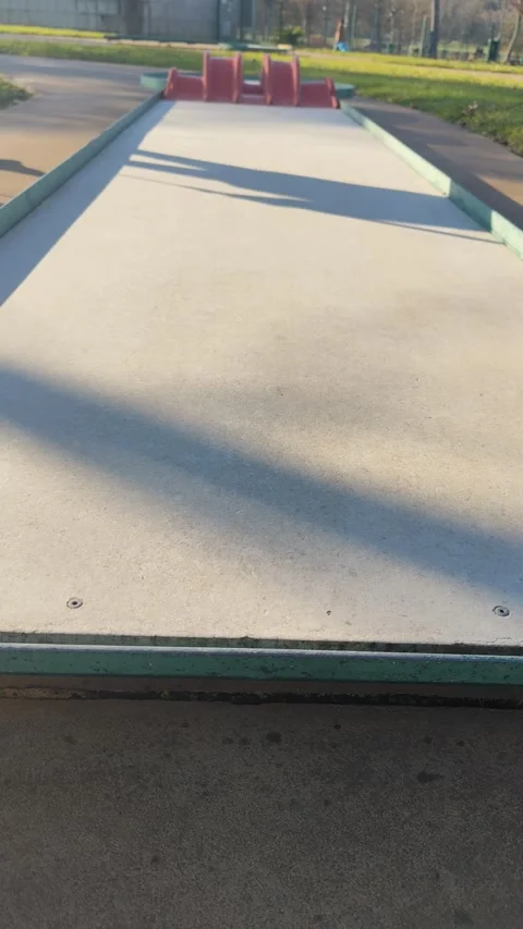Boy Successfully Putting White Ball into Red Mini Golf Ramps Stock Footage 325143205