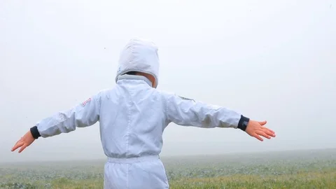 A boy in a suit of an astronaut makes circular motions. Видео 118900210