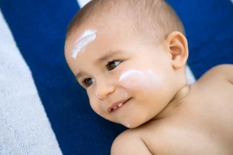 Boy with sun lotion on face Stock Photos