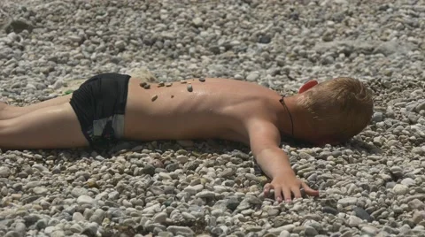 Boy sunbathing on the sea shore 库存影片 64651016