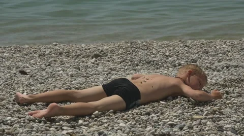 Boy sunning on the shore 库存影片 64651089