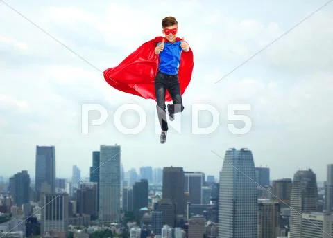 Boy in super hero cape and mask showing thumbs up Stock Photos