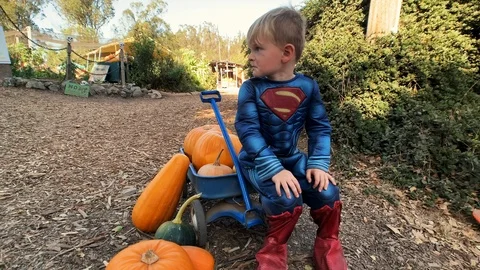 Boy superman sitting on wagon Stock Footage 118876563