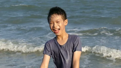 Boy in the surf on a summer beach Stock Footage 76451106
