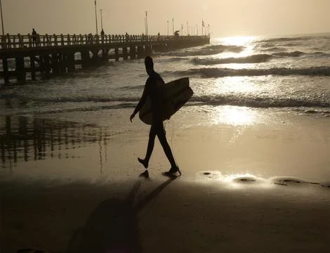A boy surf walking on the beach Stock Photos