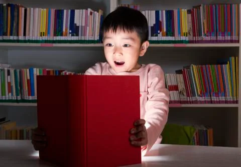 Boy Surprised By Glowing Book Stock Photos