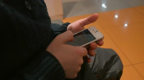 Boy in a Sweater is Playing in the Smartphone While His Parents Are Shopping at Stock Footage 61069146