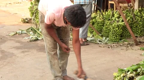 BOY SWEEPING SIDEWALK IN THIRD WORLD COUNTRY, INDIA Видео 67675433