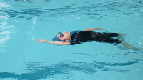Boy swimming backstroke in the pool Stock Footage 150690592