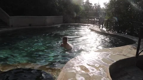 Boy swimming in clear pool in the sun Stock Footage 170893650