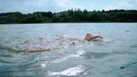 Boy swimming freestyle stroke in a lake during summer vacation Stock Footage 344684231