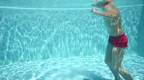 Boy in swimming trunks floating in the pool with flippers Stock Footage 34414680