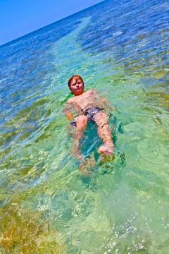 Boy swims on his back Stock Photos