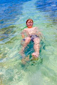 Boy swims on his back Stock Photos