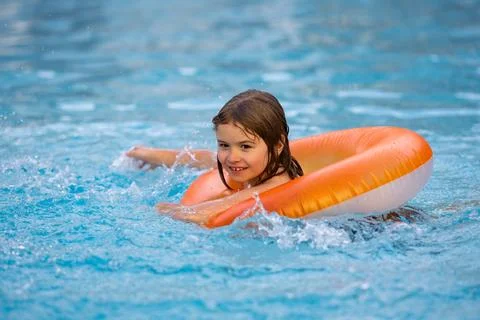 Boy swims in pool with float. Swimming, summer vacation. Child swim in pool on Stock Photos