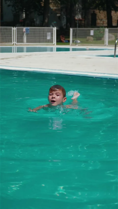 The boy swims in the pool, tries to dive and stay afloat. Stock Footage 316969014