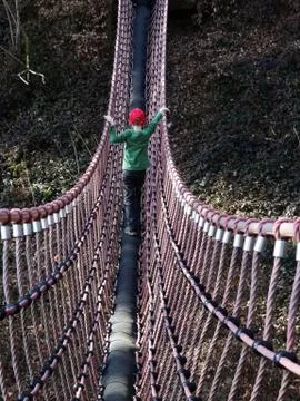 Boy on swing bridge Stock Photos