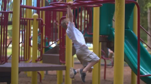 Boy Swinging Back and Forth on Monkey Bars Stock Footage 91624808