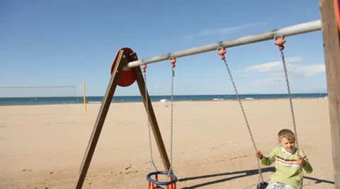 Boy swinging on the beach Stock Footage 24774270