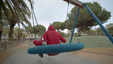 Boy Swinging in a Red Coat Video stock 165686479