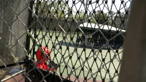 A boy swings the bat and practices little league baseball at the batting cages, Stock Footage