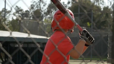 A boy swings the bat and practices little league baseball at the batting cages, Stock Footage 91744951