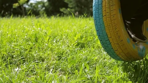 The boy swings on the wheel at midday Stock Footage 78024081