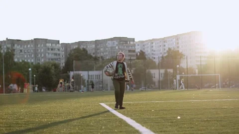 Boy in T-shirt with hero of Minecraft game walks along football field. Stock Footage 208390953