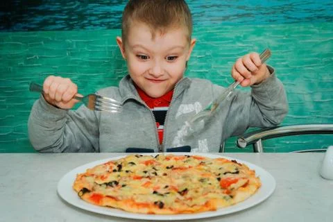 A boy at a table in a pizzeria Stock-Fotos