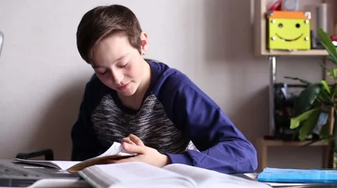 Boy at the Table Reading Video stock 63611433