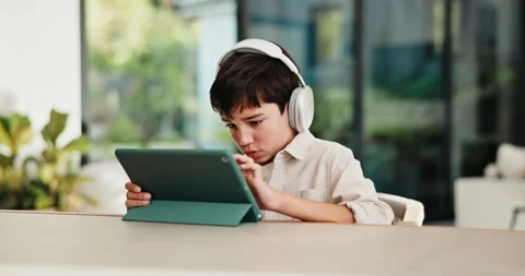 Boy, tablet and elearning with headphones in home for online interaction or Stock Footage 335525731