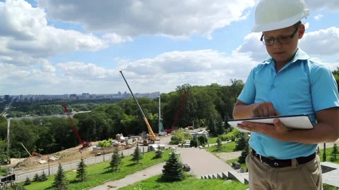 A boy with a tablet on the background of construction Stock Footage 97265659