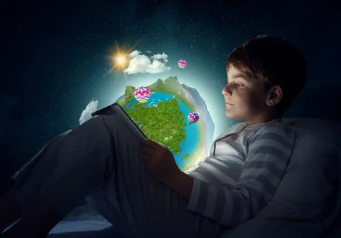 Boy with tablet in his bed Stock Photos