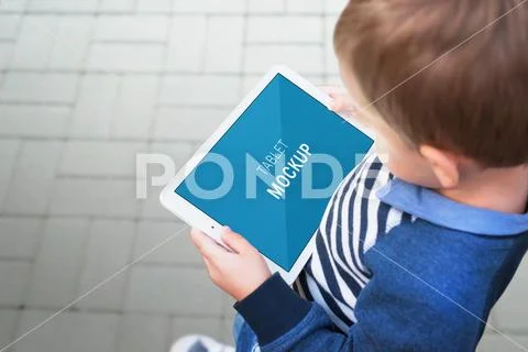 Boy with tablet mockup on city street Modello PSD