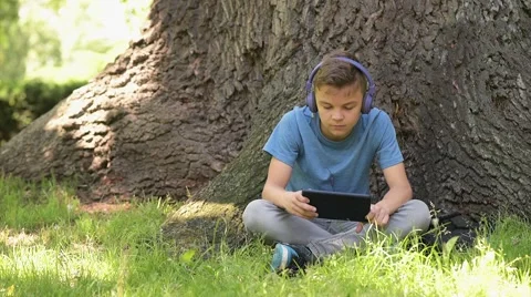 Boy with tablet at park Stock Footage 64777344