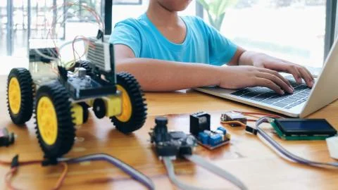 Boy with tablet pc computer programming electric toys and building robots. Stock Photos