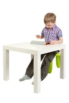 Boy with a tablet pc on the desk Stock Photos