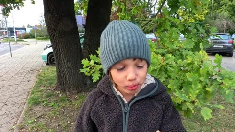 Boy Takes a Bite of a Donut and Enjoys the Taste with a Smile Video stock 253485772