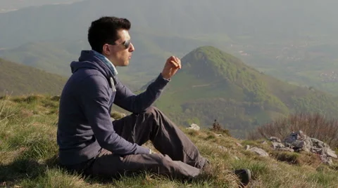 Boy takes a break on top of the mountain looking at the view Stock Footage 49750596