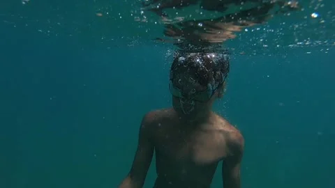 The boy takes a deep breath and dives deep underwater Vídeos de archivo 240395726