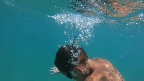 The boy takes a deep breath and dives into the depths of the sea Vídeos de archivo 243602398