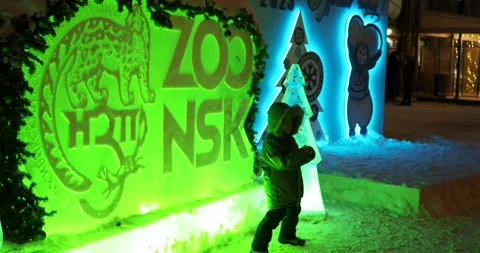 The boy takes different poses when he is photographed near the illuminated stand Video stock 228222897