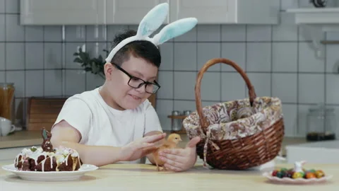 A boy takes an Easter newborn chick out of a basket. Stock Footage 303622174