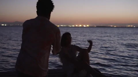 Boy takes a flash photo of his girlfriend in a beautiful sunset Stock Footage 257589666