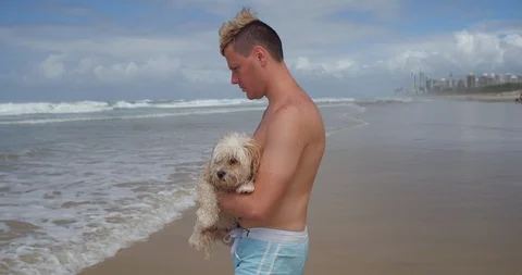 Boy takes his scared dog into the water Video stock 87976523