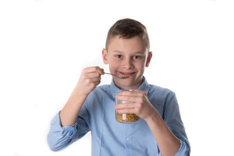 Boy takes propolis from bees with a spoon to stay healthy Stock Photos